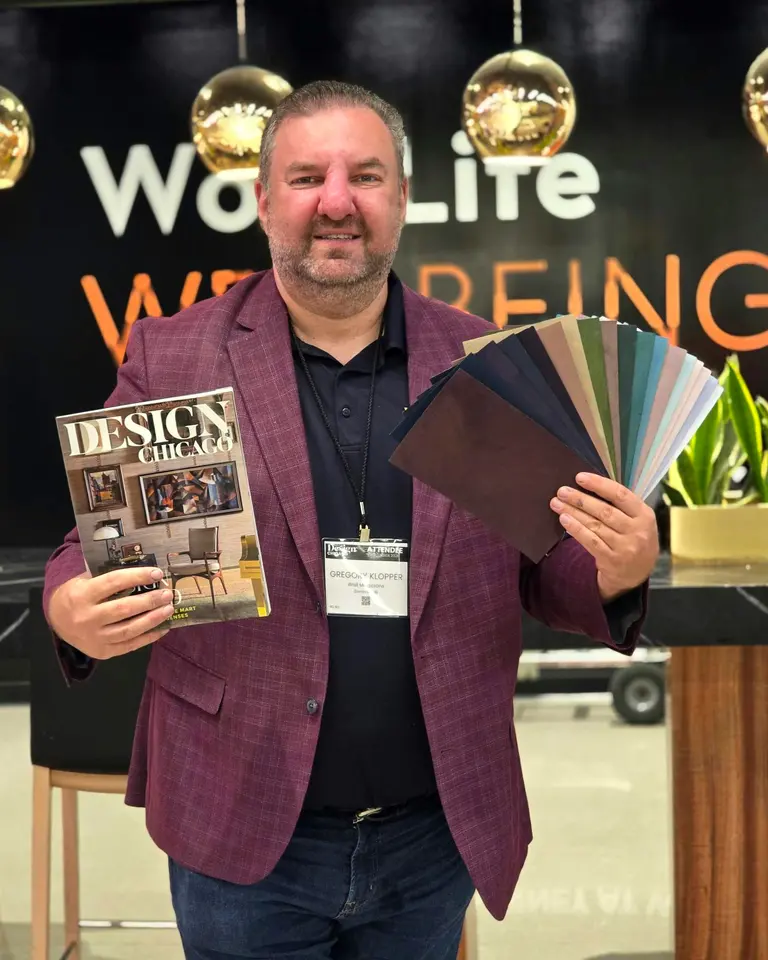 Greg Klopper smiling, holding a copy of Design Chicago and a fan of The Turn’s colors