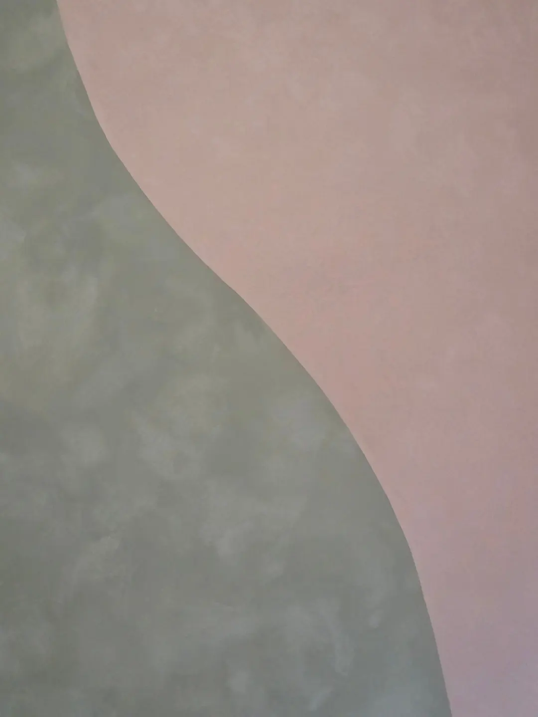 Close view of sage and peach lime plaster meeting in a smooth curve