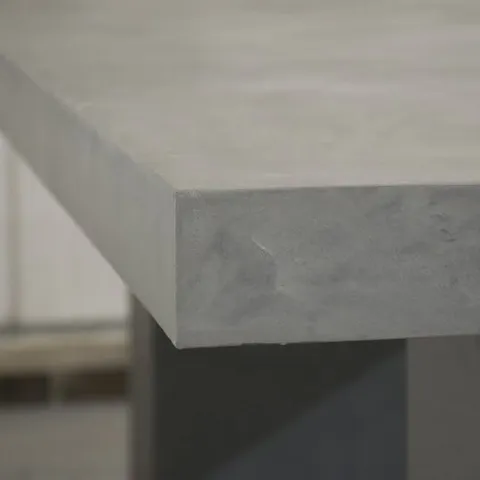 Close view of a gray microcement countertop corner, its crisp edge and softly clouded surface