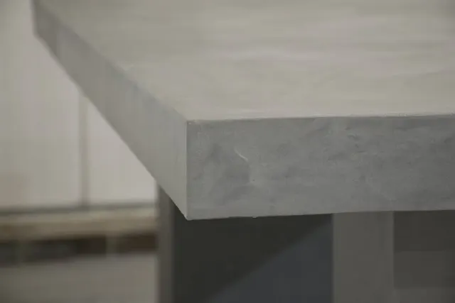 Close view of a gray microcement countertop corner, its crisp edge and softly clouded surface