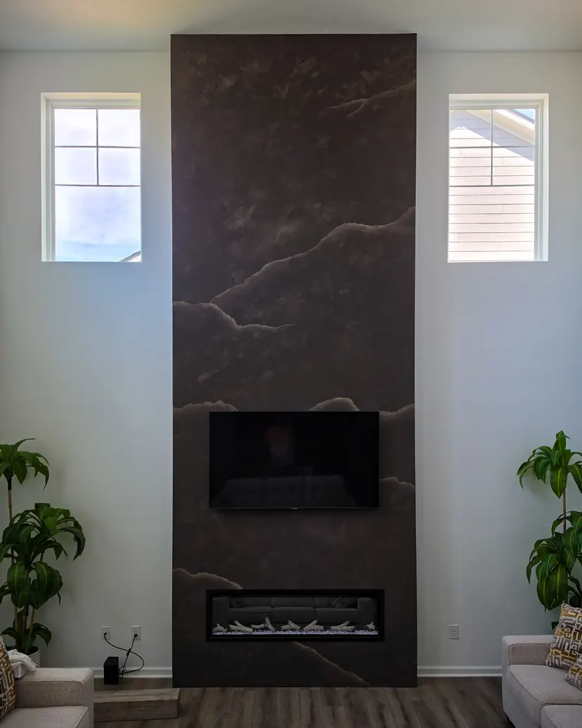 Fireplace column finished in espresso-brown limewash that reads as veined marble, in a Carmel home