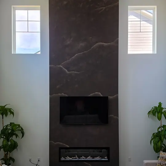Fireplace column finished in espresso-brown limewash that reads as veined marble, in a Carmel home
