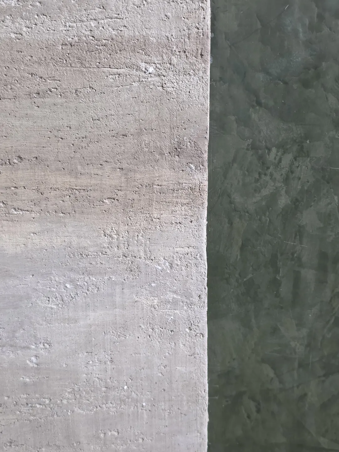 Close view of the faux travertine surround beside the smoky green Roman clay