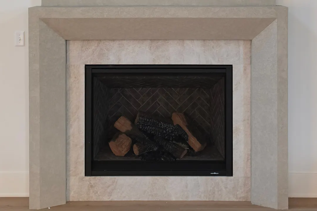 Fireplace column and mantel in a warm gray, concrete-look plaster with a tactile texture, in a Westfield home