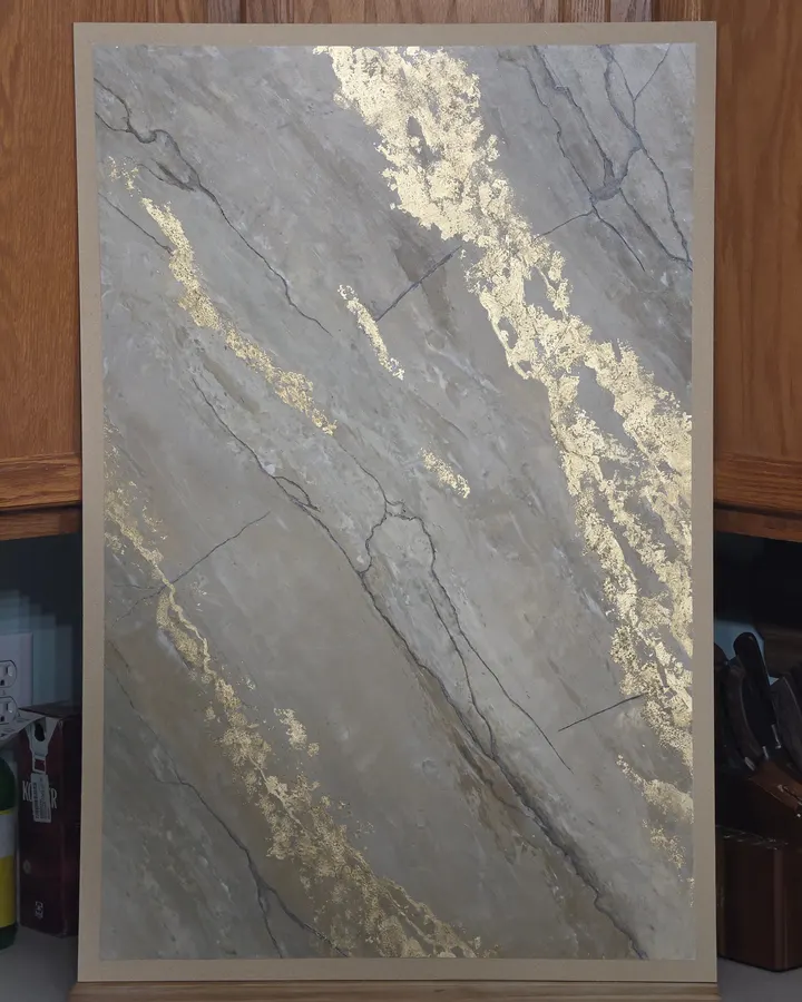 A faux marble sample board in warm mushroom with veins of gold