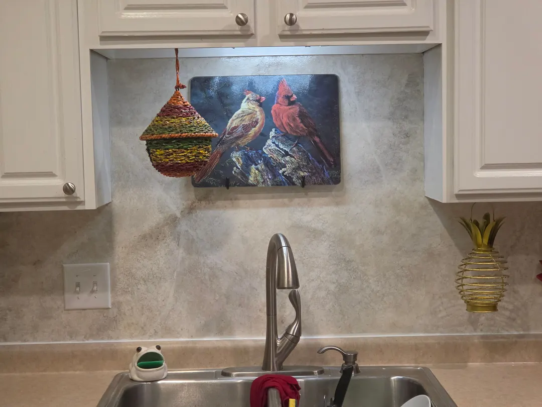 Kitchen backsplash in a textured Indiana limestone finish under white cabinets, in a Zionsville home