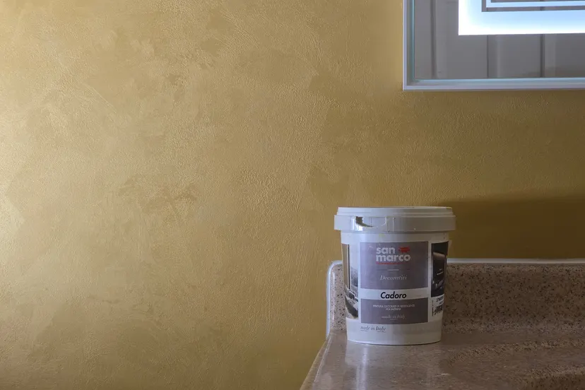 Close view of the golden wet silk finish above the counter, with a bucket of the finish on the counter